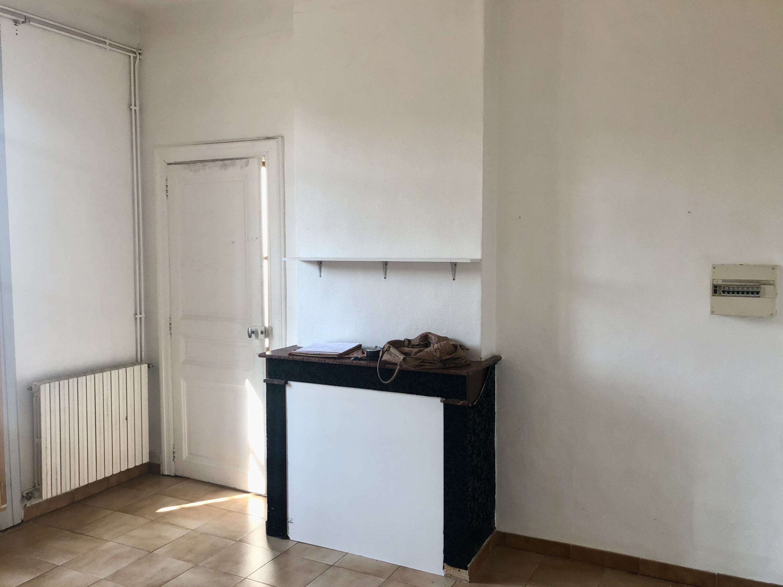 Salon avec cheminée condamnée avant rénovation appartement ancien Montpellier