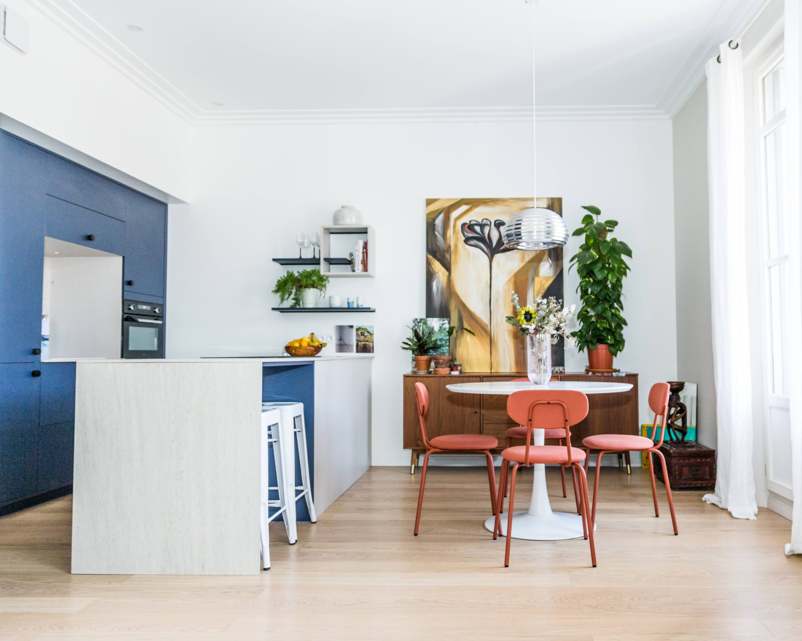 Séjour lumineux avec table ronde et chaises corail rénovation Montpellier